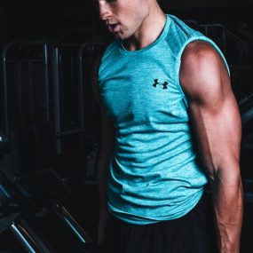 Man exercising indoors, lifting dumbbells for strength training in a Towson gym.